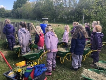 Elever på vej med fyldte trillebøre