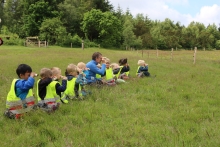 Børn med kikkert skuer udover mark