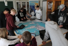 Eleverne står rundt om spillepladen, hvor de skal vinde miner fra hinanden.