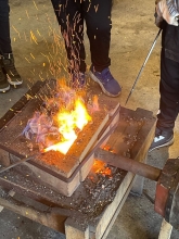 Elever smeder ved esse i Ildmagerens Værksted Skoletjenesten Lindholm Høje foto Nicolaj Schaumann